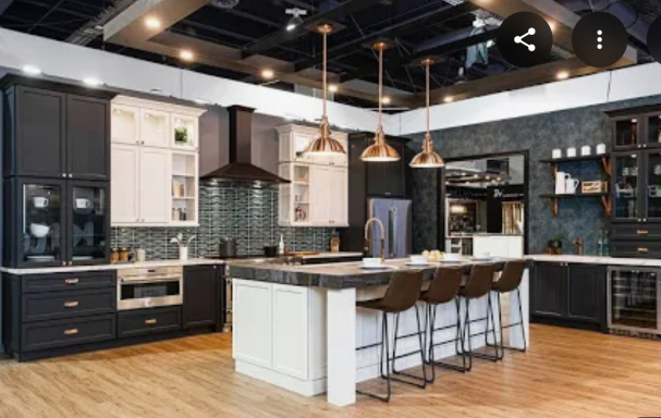 Modern kitchen with dark cabinetry, a large island, pendant lights, and stainless steel appliances.