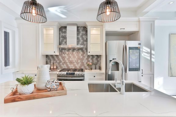 Modern kitchen with white cabinets, stainless steel appliances, and a decorative backsplash.