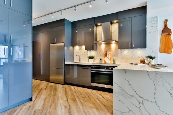 Modern kitchen with dark cabinets, stainless steel appliances, and marble accents.
