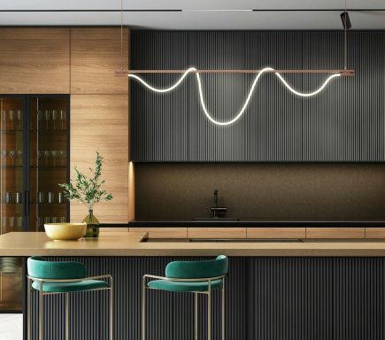 Modern kitchen with a wavy pendant light and green bar stools against wood and dark cabinetry.