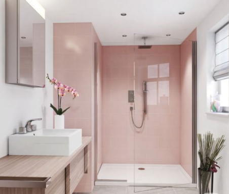 Modern bathroom featuring a glass shower, pink walls, and a sink with a wooden vanity.