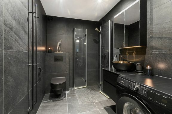 Modern black bathroom with a shower, vanity, and sleek fixtures.